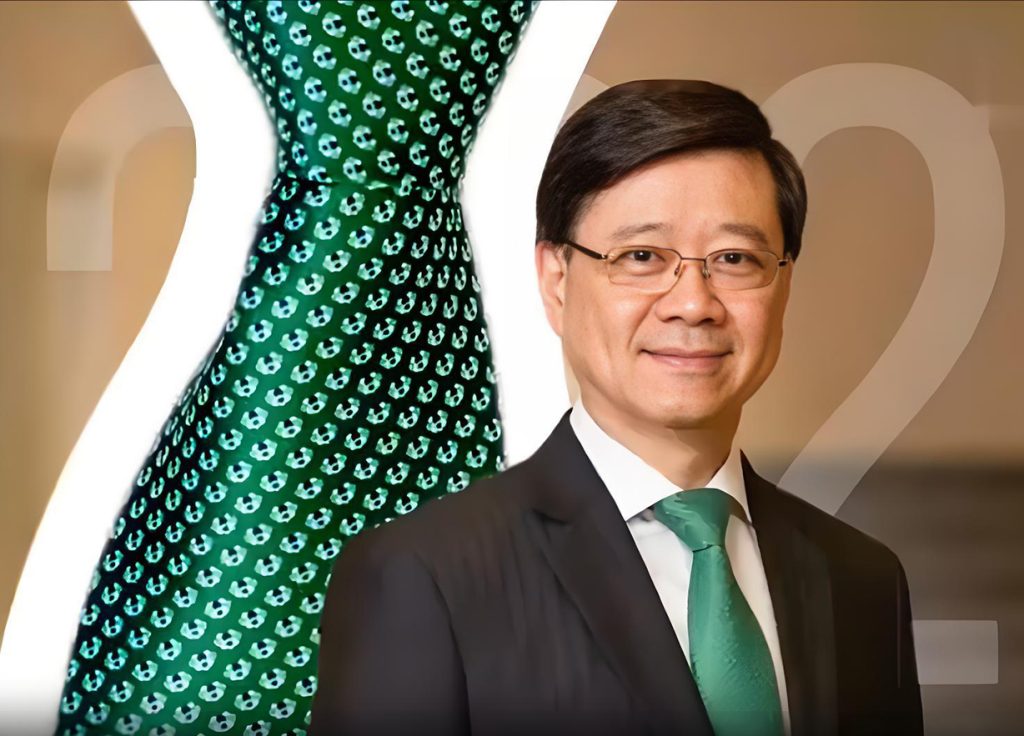 李家超将戴港校师生设计绿调配饰发表施政报告，以大桥元素喻香港 “东西之桥” 角色